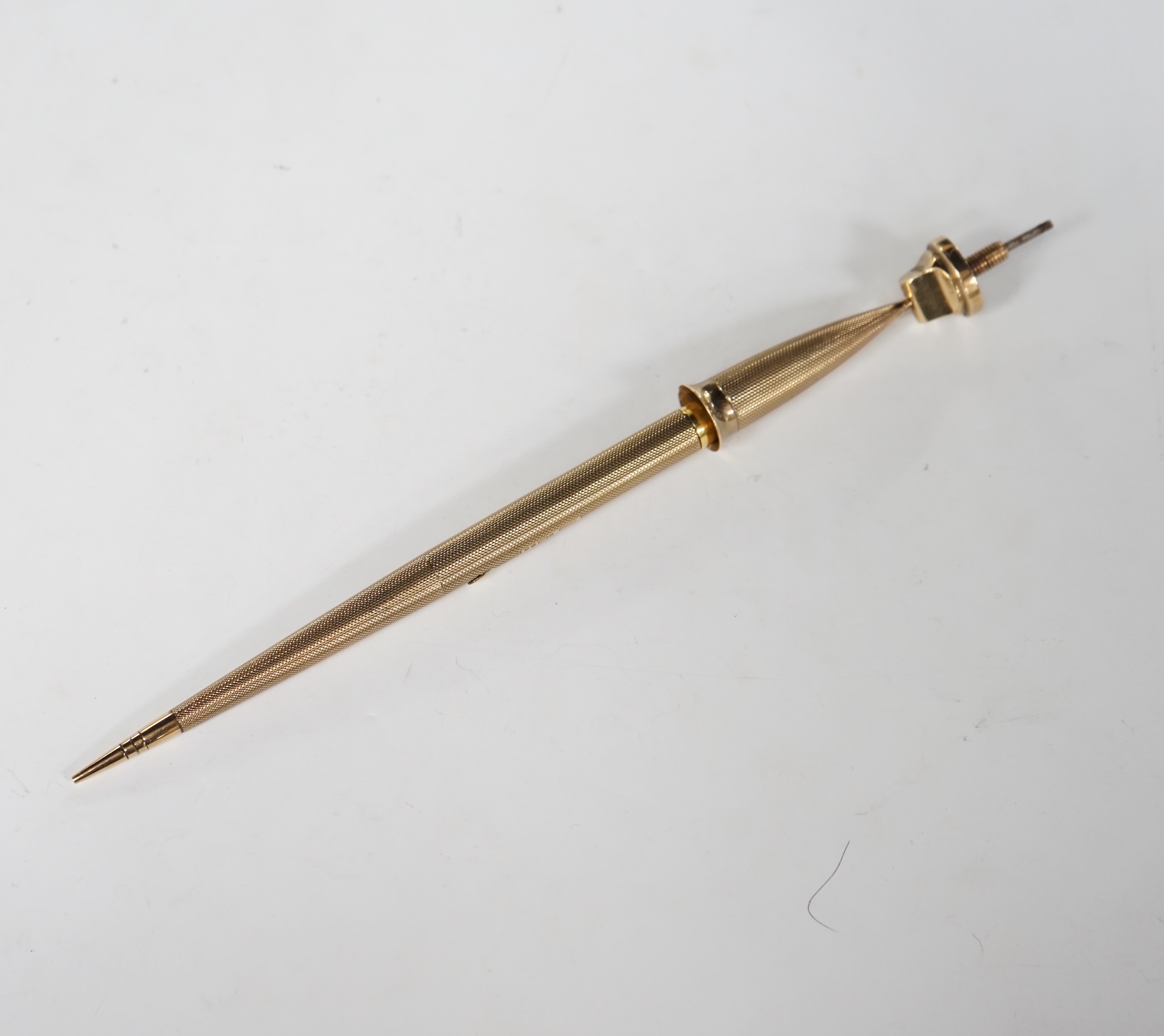 A George V engine turned 9ct. gold combination fountain pen and pencil, with holder (once attached to a stand), maker F.D.W. London, 1935, 20.4cm.